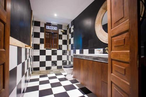a bathroom with a black and white checkered floor at Hailsham Bungalow in Sri Jayewardenepura Kotte