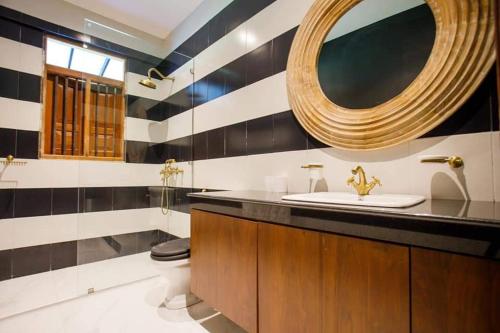 a bathroom with a sink and a mirror at Hailsham Bungalow in Sri Jayewardenepura Kotte