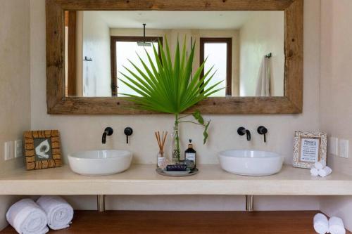 图卢姆Jungle Lounge Barefoot Luxury 3BR Two Level Penthouse with Pool in Luum Zama的浴室里有两个洗手池和一面镜子