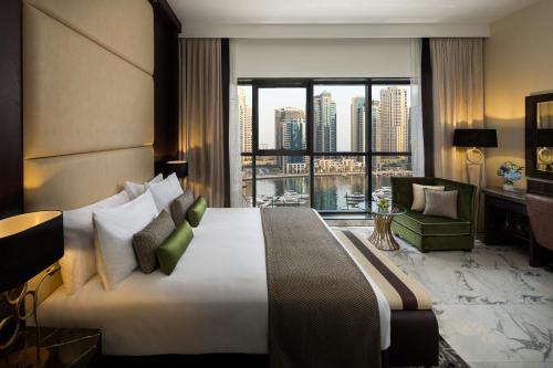 ein Hotelzimmer mit einem großen Bett und einem großen Fenster in der Unterkunft Millennium Place Dubai Marina in Dubai