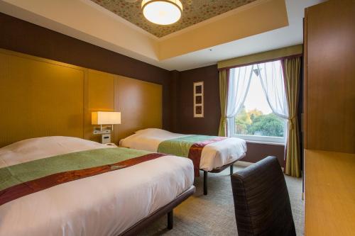 ein Hotelzimmer mit 2 Betten und einem Fenster in der Unterkunft Hotel Monterey Akasaka in Tokio