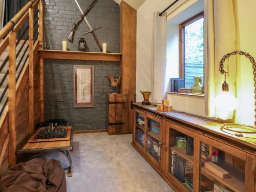 uma sala de estar com lareira e uma cómoda em madeira em Wheatlow Brooks Barn em Stafford