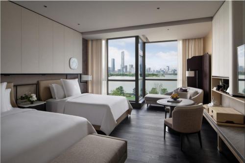 a hotel room with two beds and a couch at Four Seasons Hotel Suzhou in Suzhou