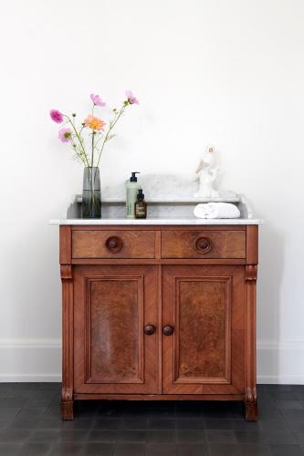 a bathroom sink with a vase of flowers on it at Signau House & Garden Boutique Hotel Zürich in Zürich