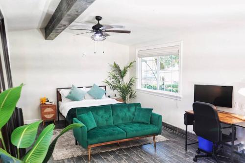 a bedroom with a green couch and a bed at Casita Hosum: Modern WFH Garden Suite w/ Gazebo Outdoor Kitchen & BBQ in San Jose