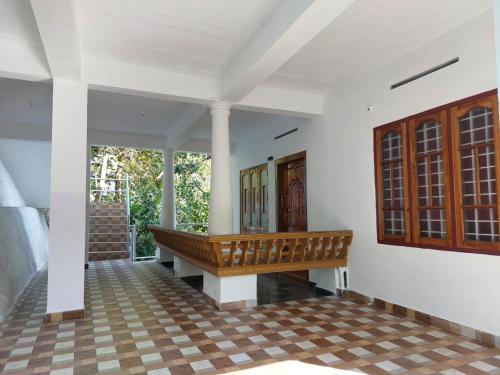 - une terrasse couverte avec un banc en bois dans l'établissement Shalom Homestay Thekkady, à Thekkady