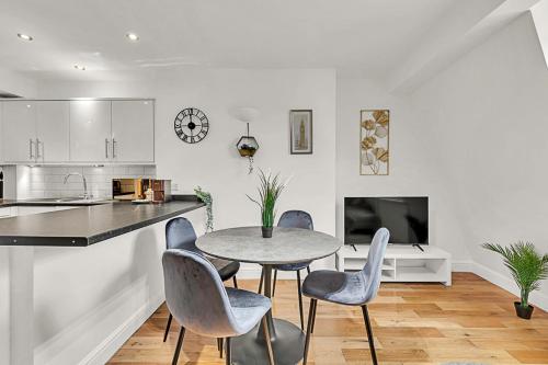 eine Küche und ein Esszimmer mit einem Tisch und Stühlen in der Unterkunft Contemporary Oasis in Paddington III in London