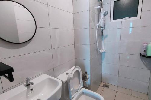a bathroom with a sink and a toilet and a mirror at Biubiu Home in Melaka