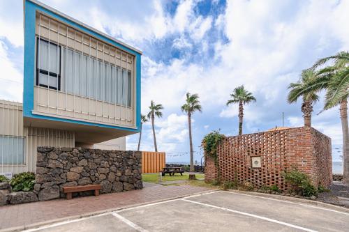 a building with a basketball court and palm trees at Boutique Pool Villa NAMIB in Jeju