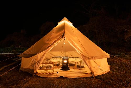 biały namiot ze światłem w ciemności w obiekcie 長崎鼻ビーチリゾート w mieście Kakaji