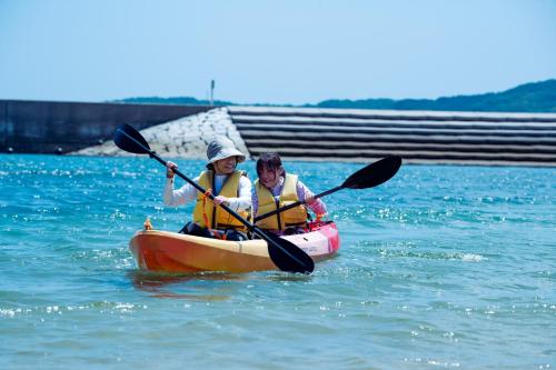 two people are in a kayak in the water at 長崎鼻ビーチリゾート in Kakaji