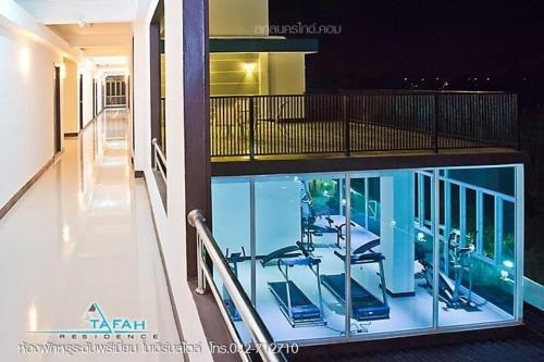 a building with a swimming pool with chairs on a balcony at ตาฟ้าเรสซิเดนซ์ (Tafah Residence) in Sakon Nakhon