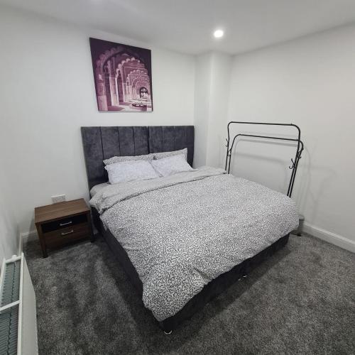 ein Schlafzimmer mit einem Bett und einem Nachttisch in der Unterkunft 3 bedroom home - Meadowhall, Magna, Utilita arena, free parking, garden in Templebrough