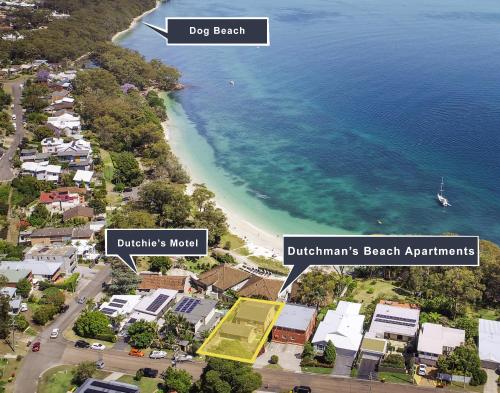 a view of a beach with houses and the ocean at Dutchies Motel Nelson Bay & Dutchmans Beach Apartments in Nelson Bay