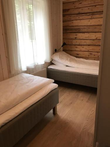 two beds in a room with a window at Gammelstua Seaview Lodge in Kongsjorda