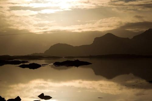 a body of water with mountains in the background at Gammelstua Seaview Lodge in Kongsjorda