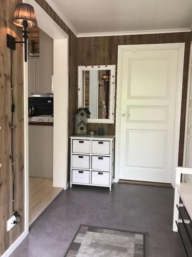 a room with a door and a dresser with a mirror at Gammelstua Seaview Lodge in Kongsjorda