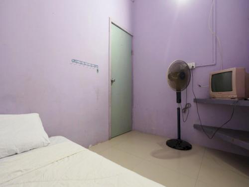 uma sala com um quarto com uma cama e uma televisão em SPOT ON 93276 Fendi 2 Homestay Syariah em Nagoya