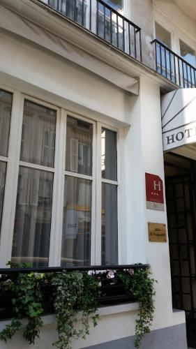 a white building with windows and a balcony at Hôtel Le Compostelle in Paris