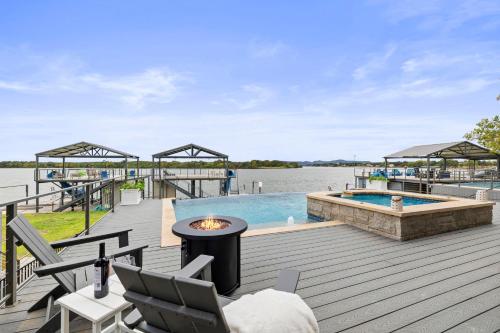a wooden deck with a pool and a fire pit at Luxury Waterfront Home with Swimming Pool Hot Tub and 2 Boat Slips in Kingsland