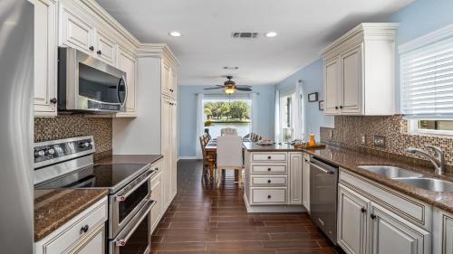 a kitchen with white cabinets and a sink and a table at Waterfront House with Amazing Outdoor Oasis Boat Slip and Pet Friendly in Kingsland