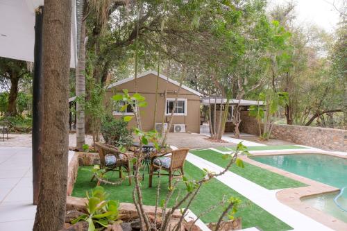 um quintal com um relvado verde e uma piscina em Kadima Safari Lodge em Hoedspruit