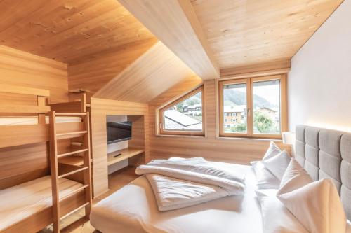 ein kleines Schlafzimmer mit einem Bett und ein Zimmer mit einem Etagenbett in der Unterkunft Schrannenhof in Schoppernau