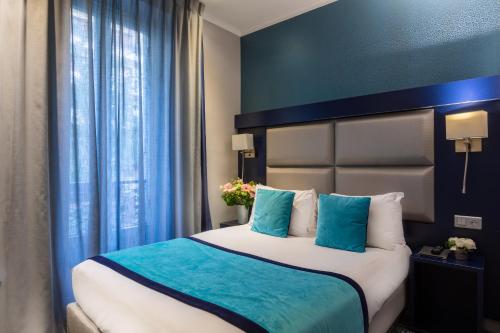 a bedroom with a large bed with blue and white pillows at Prince Albert Montmartre in Paris
