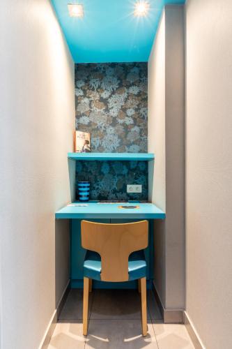 a blue desk with a chair in a room at Prince Albert Montmartre in Paris