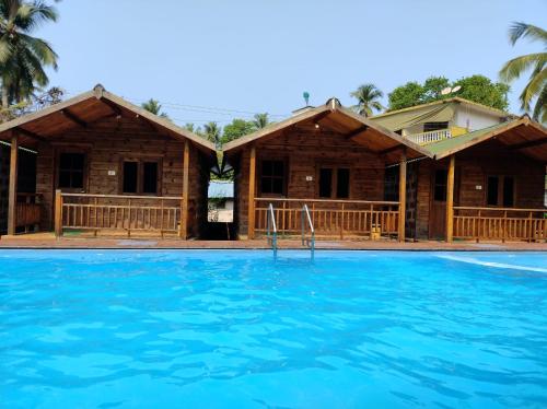 a house with a swimming pool in front of it at TP cottages Beach Resort in Arambol