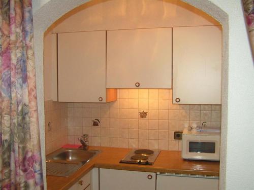a kitchen with a sink and a microwave at Gästehaus Alpenruh in Holzgau