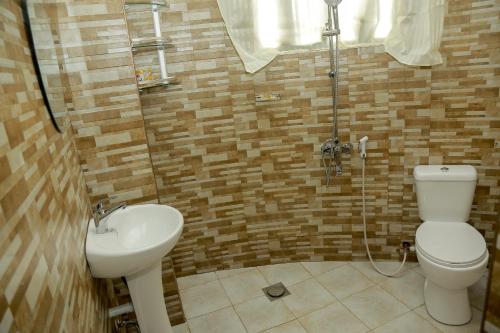 een badkamer met een toilet en een wastafel bij Wademac Arusha Inn Hotel in Arusha