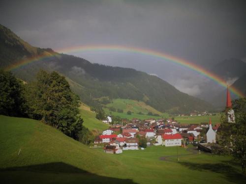 a rainbow over a small town with a village at Alpenview Lechtal in Holzgau