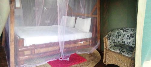 a bedroom with a wooden bed with a canopy at Lake Manyara View Luxury Tented Camp in Mto wa Mbu