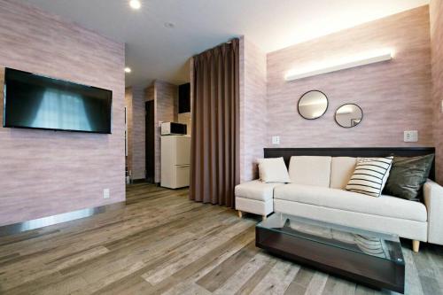 a living room with a couch and a flat screen tv at ザ・マスターズステイ世田谷経堂 201 in Tokyo