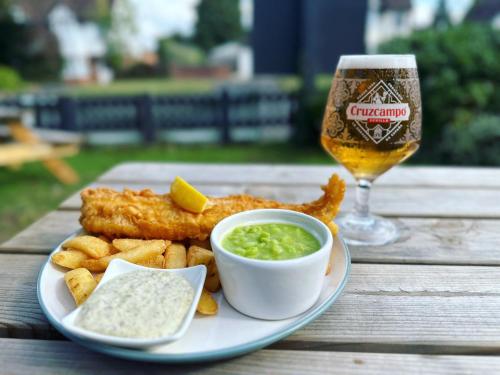 a plate of food with fish and chips and a glass of beer at The Old Tramway - Stay in YOUR Motorhome - parking space on the car park in Stratford-upon-Avon