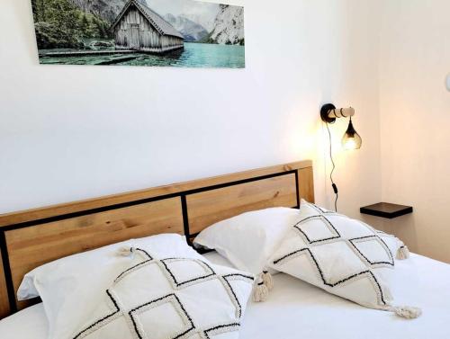 uma cama com duas almofadas e uma fotografia na parede em Browny Home*Vue montagne*proximité grands axes em Bonneville