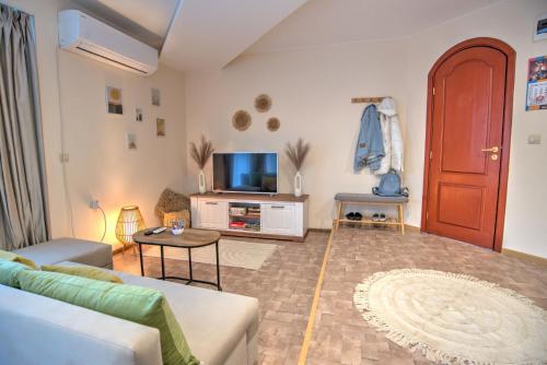 salon z kanapą i telewizorem w obiekcie Вила Capitalica Forte w mieście Pamporowo