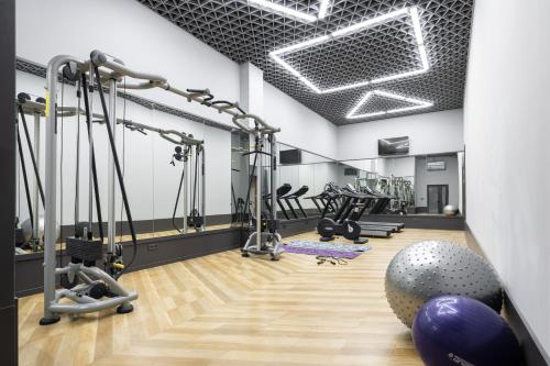 einen Fitnessraum mit Laufbändern und einem großen Trainingsball in der Unterkunft Shamsan Airport Hotel in Taschkent