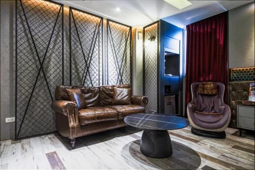 a living room with a leather couch and a table at Wsb Motel-Rende in Tainan