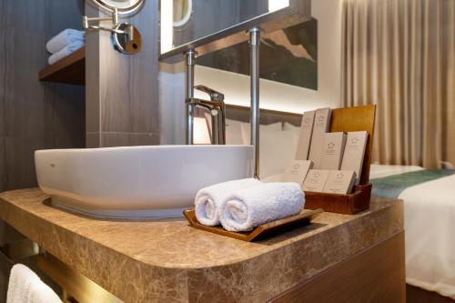 a bathroom with a sink and towels on a counter at Marianna Resort & Convention Tuktuk Samosir in Ronggurnihuta
