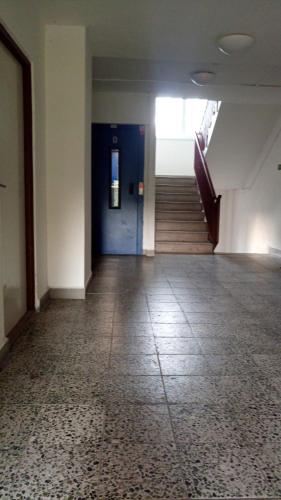 an empty hallway with a blue door and stairs at Apartmány Karviná in Karviná