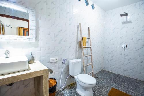 a bathroom with a toilet and a sink and a ladder at The Nest Canggu in Canggu