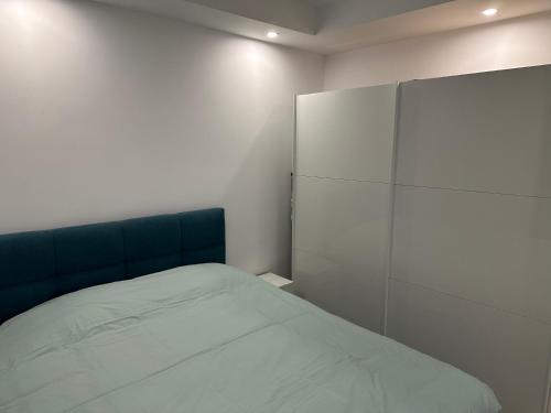 a bedroom with a bed and a white wall at Adagio apartment in Creţuleasca