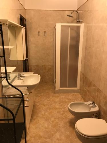 a bathroom with two sinks and a toilet and a shower at Appartamento Alfieri in Asti
