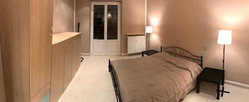 a bedroom with a bed and a table and lamp at Appartamento Alfieri in Asti
