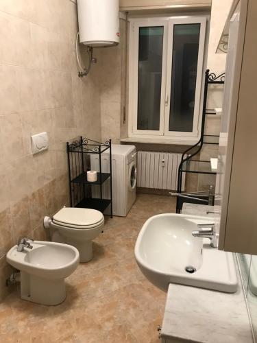 a bathroom with a toilet and a bidet and a sink at Appartamento Alfieri in Asti