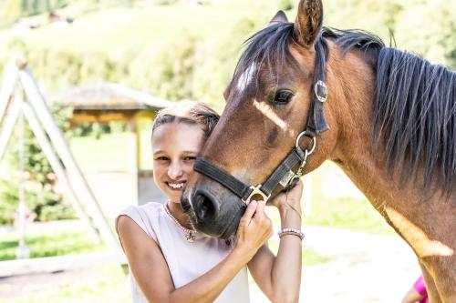 a young girl is standing next to a horse at Schrannenhof in Schoppernau
