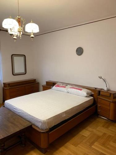 Schlafzimmer mit einem Bett und einem Kronleuchter in der Unterkunft Appartamento - Châtillon in Châtillon