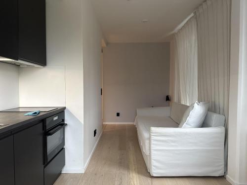 ein Wohnzimmer mit einer weißen Couch in einem Zimmer in der Unterkunft Apartment in Sollentuna Centrum 1205 in Sollentuna